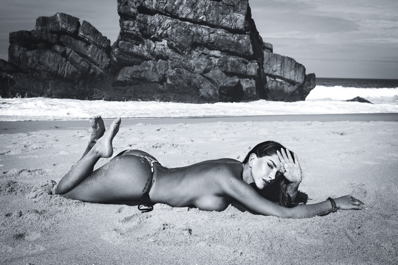 Vicentta lying on the sand in black and white